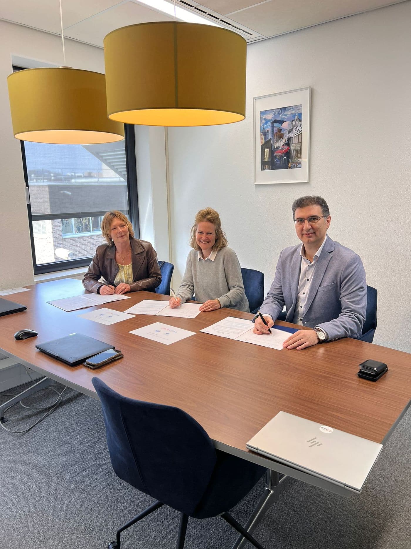 De heer Cerit (Humane Zorg Group), mevrouw Bults (Q-Consult Zorg) en mevrouw Van der Sluis (Mysoly) ondertekenen de samenwerkingsovereenkomst van CareOns